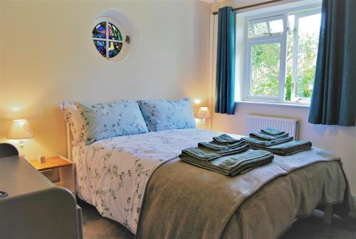 1 dormitorio con 1 cama con toallas en The Cottage Garden - A Herefordshire Retreat, en Ross-on-Wye