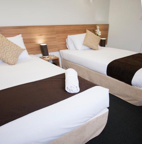 two beds in a hotel room next to each other at Ascotia Off Queen in Auckland