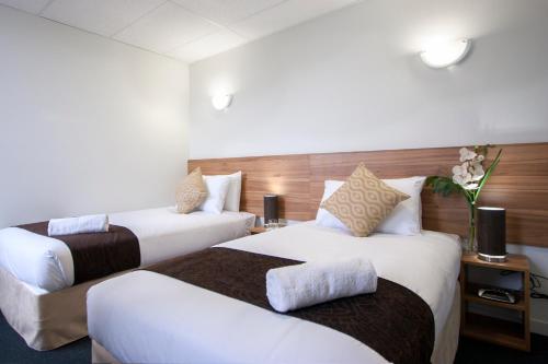 a hotel room with two beds and a couch at Ascotia Off Queen in Auckland
