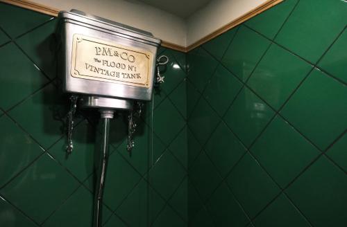 a sign in a bathroom with a green wall at URSIDE Hotel Shanghai The Bund in Shanghai