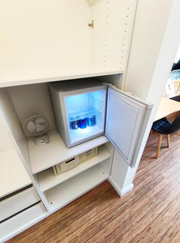 a small refrigerator in a cabinet in a room at Schäfers Hotel, Self-Check-in, Cafe und Bäcker am Hotel in Vechta