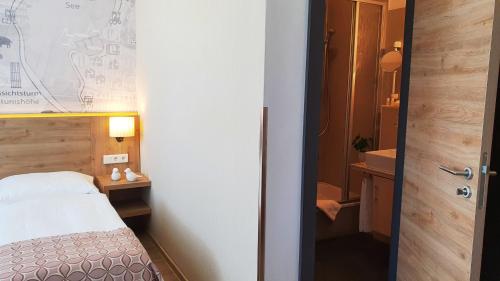a small room with a bed and a bathroom at Hotel Atlas Halle in Halle an der Saale