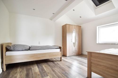 a bedroom with a bed and a wooden cabinet at Moderne Ferienwohnung mit Sat-TV & WLAN in Leverkusen