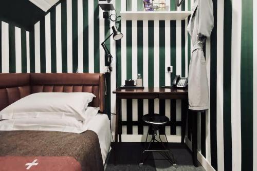 a bedroom with a bed and a table with a lamp at URSIDE Hotel Shanghai The Bund in Shanghai