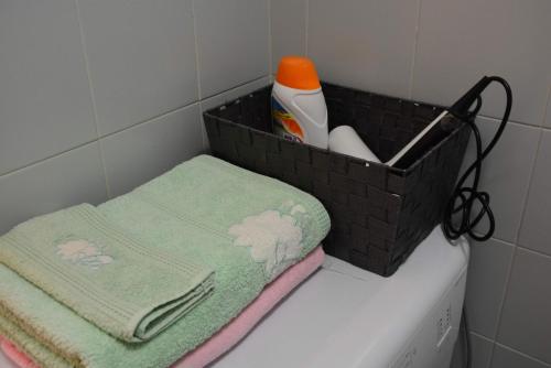 kosz z pralką i ręcznikami w obiekcie Apartamento del Niño w mieście Campoamor