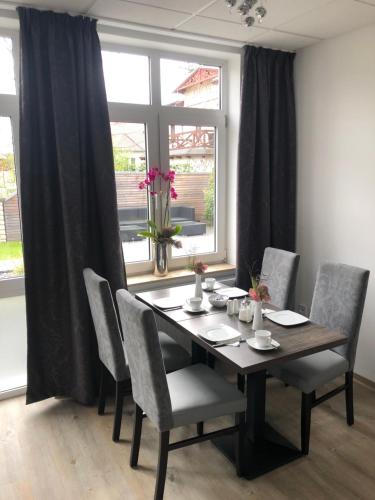 a dining room table with chairs and a large window at Pension Arcade in Dresden