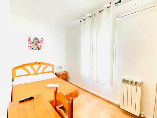 1 dormitorio con cama, mesa y ventana en CH Rayuela, en Madrid