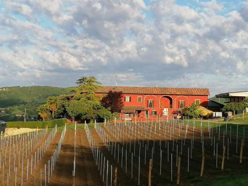 a red building with a bunch of vineyards at La Bella Vite in Moncalvo