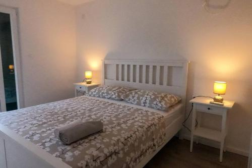 um quarto com uma cama branca com 2 mesas e 2 candeeiros em KN House with two apartments near sea em Rogoznica