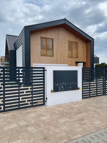 a building with a fence and a sign on it at Nova Apartamenty Rewa in Rewa