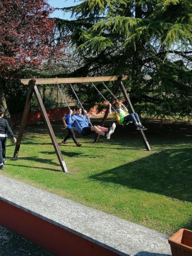 a group of people sitting on a swing in a park at La Bella Vite in Moncalvo