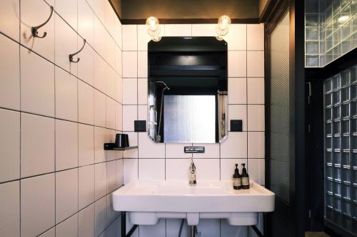 a bathroom with a white sink and a mirror at URSIDE Hotel Shanghai The Bund in Shanghai