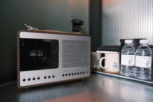 a microwave sitting on a counter with two mugs and glasses at URSIDE Hotel Shanghai The Bund in Shanghai