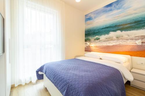 a bedroom with a bed and a painting of the ocean at VineWood Apartment, By Cohost in Palanga