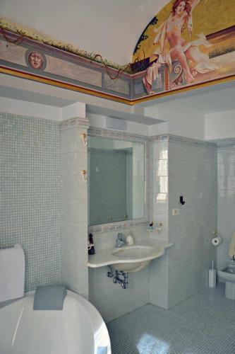 a bathroom with a tub and a sink and a mirror at B&B Cornelia in Atri