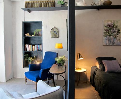 ein Wohnzimmer mit einem blauen Stuhl und einem Sofa in der Unterkunft les Lauriers in Caromb