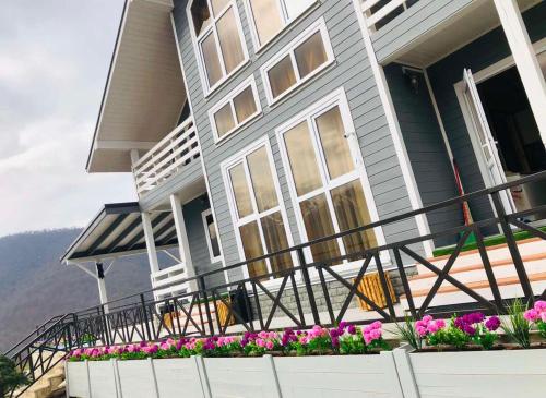 a house with a balcony with flowers on it at COTTAGE CHALET and TOURS in Dilijan