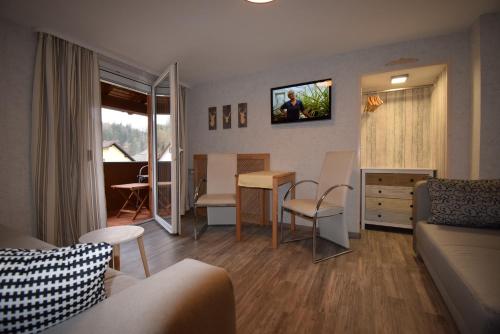 ein Wohnzimmer mit einem Sofa und einem Tisch in der Unterkunft Gasthof Roseneck in Wallenfels