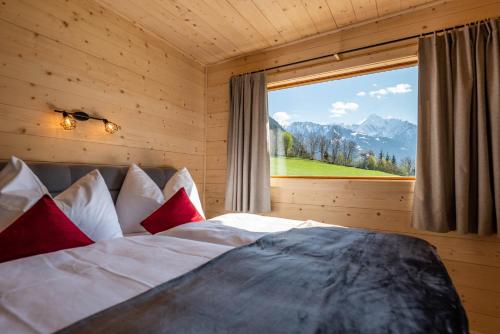 a bedroom with a bed with a large window at STAUDACH - Alpinresidenz Zillertal in Ramsau im Zillertal