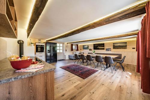 uma cozinha em plano aberto e sala de estar com um balcão e cadeiras em STAUDACH - Alpinresidenz Zillertal em Ramsau im Zillertal