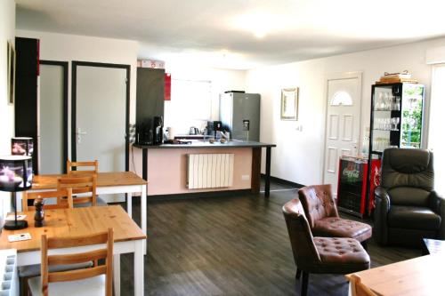 a living room with a table and chairs and a kitchen at BonAbri Vacances - Chambres d'hôtes in Chazelles