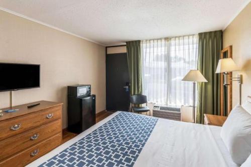 um quarto de hotel com uma cama e uma televisão de ecrã plano em Smart Extended Stay em Beckley