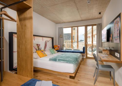 sypialnia z dużym łóżkiem, biurkiem i biurkiem w obiekcie Hotel Blü Gastein w mieście Bad Hofgastein