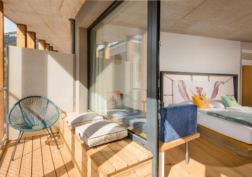 a room with a bed and a glass wall at Hotel Blü Gastein in Bad Hofgastein