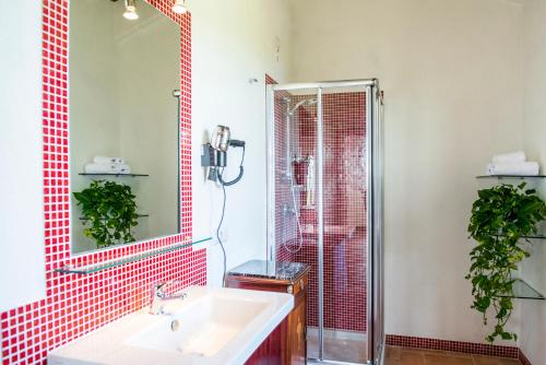 a bathroom with a sink and a shower with red tiles at BOSSONCINA 8&1, Emma Villas in Montepulciano