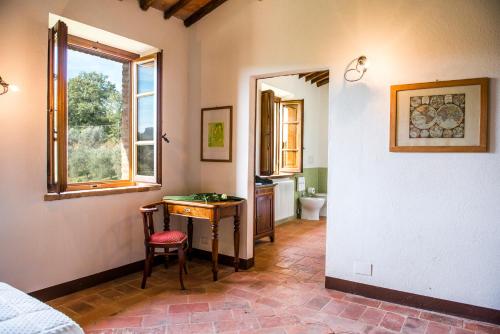 Cette chambre comprend un bureau, une fenêtre et une salle de bains. dans l'établissement BOSSONCINA 8&1, Emma Villas, à Montepulciano