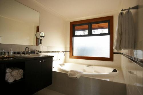 
a bathroom with a sink, toilet and bathtub at Lazy River Boutique Bed & Breakfast in Pinjarra
