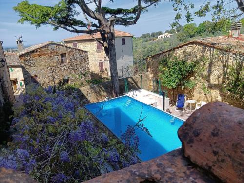 ビッボーナにあるLocanda Etruscaの建物のある庭の青いスイミングプール