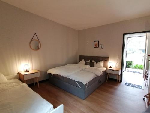 1 dormitorio con 1 cama grande y 2 mesitas de noche en Waldjugendherberge Uelsen, en Uelsen