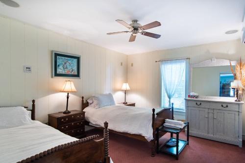a bedroom with two beds and a ceiling fan at Emilyville Inn in Campbellford