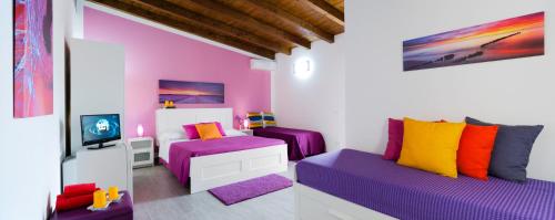 a room with purple and colorful pillows at Arricàmpati Airport Rooms & Bringo Car Rental in Carini