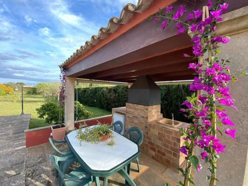a table and chairs on a patio with purple flowers at Villa Mallorca Paradise in Llucmajor
