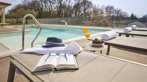 a table with a book and a hat and glasses at Villa Grgo by Villas Holiday in Tinjan