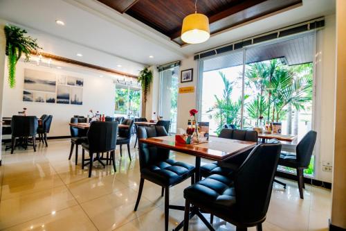 a dining room with a table and chairs at Rapeepan Ville Hotel in Ubon Ratchathani