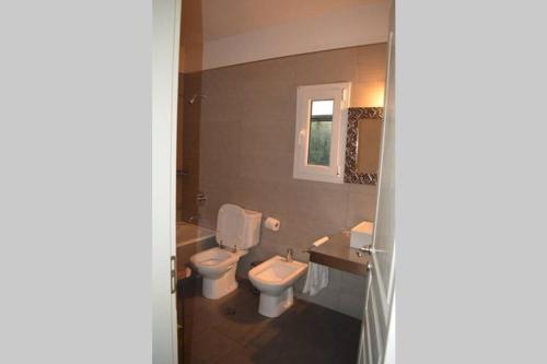 ein Badezimmer mit Toilette und Waschbecken in der Unterkunft CASA AL LADO DEL MAR in Balneario El Cóndor