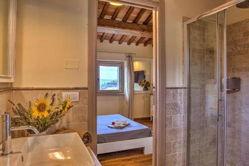 un bagno con doccia e un letto in una camera di CASALE DEI GELSOMINI 8, Emma Villas a Todi