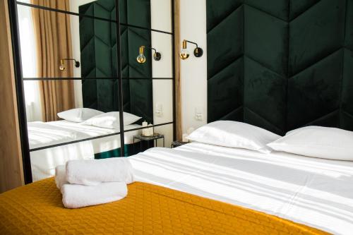 een slaapkamer met een groot bed en een spiegel bij Emerald Room in Toruń