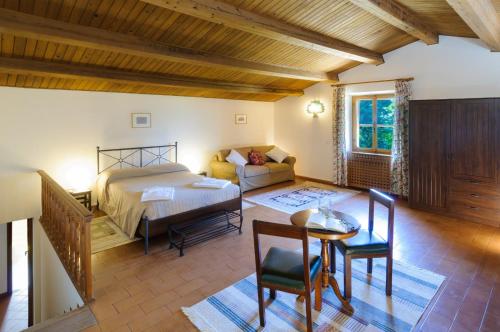 MondainoにあるConvento di San Francesco Mondainoのベッドルーム1室(ベッド1台、テーブル、ソファ付)