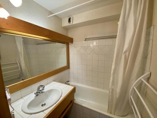 a bathroom with a sink and a mirror and a tub at La Troïka in Notre-Dame-de-Bellecombe