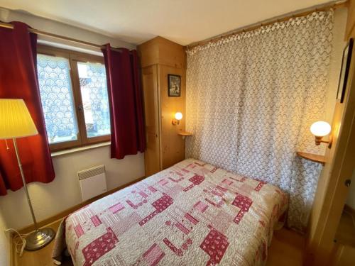 a small bedroom with a bed and a window at La Troïka in Notre-Dame-de-Bellecombe