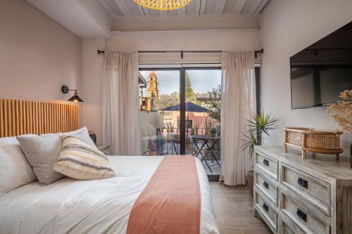 1 dormitorio con 1 cama y balcón con mesa en Casa Pandurata Luxury Apartments in Centro, San Miguel de Allende en San Miguel de Allende