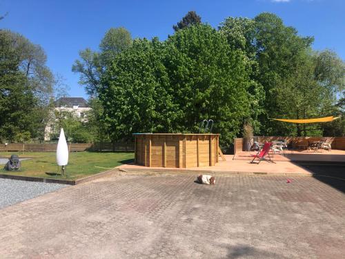 un cane sdraiato a terra davanti a un parco di Les Papoulis a Saint-Laurent-sur-Sèvre