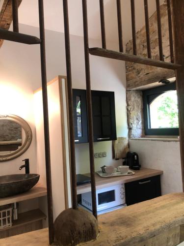 une cuisine avec un évier et un micro-ondes dans l'établissement La grange du cleray, à Vallet