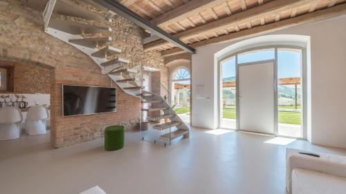 a spiral staircase in a room with a brick wall at Dimora Montefiore 11, Emma Villas in Montefiore dellʼAso