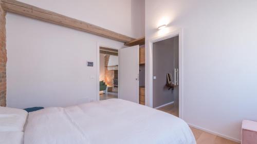 a bedroom with a white bed and an open door at Dimora Montefiore 11, Emma Villas in Montefiore dellʼAso