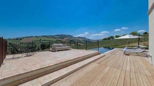a backyard with a wooden deck and a swimming pool at Dimora Montefiore 11, Emma Villas in Montefiore dellʼAso